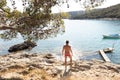 Rear view of man wearing red speedos tanning and realaxing on wild cove of Adriatic sea on a beach in shade of pine tree Royalty Free Stock Photo