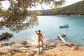 Rear view of man wearing red speedos tanning and realaxing on wild cove of Adriatic sea on a beach in shade of pine tree Royalty Free Stock Photo