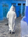 Rear view of man in white jillaba walking in Chefchauen, Morocco