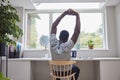 Rear View Of Man Working From Home On Computer  In Home Office Stretching At Desk Royalty Free Stock Photo