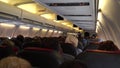 The rear view of the many people on the plane. Interior of airplane with passengers, sitting on seats. The concept of travelling