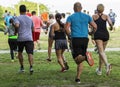 Rear view of many runners running on grass during race