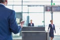 Rear view of mature businessman holding his passport and boarding pass at airport Royalty Free Stock Photo