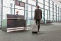 Rear view of mature businessman walking with his suitcase on his gate for boarding in airport Royalty Free Stock Photo