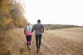 Rear View Of Mature Couple Running Around Autumn Field Royalty Free Stock Photo