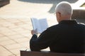 Rear view of a mature man reading a book Royalty Free Stock Photo