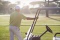 Rear view of mature man standing by golf buggy Royalty Free Stock Photo