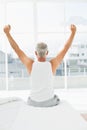 Rear view of mature man stretching arms in bed Royalty Free Stock Photo