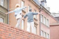 Rear view of middle-aged couple with arms outstretched walking on brick wall Royalty Free Stock Photo