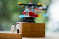 Rear view of miniature doctor and nurse walking towards helicopter
