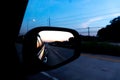 Rear View Mirror Reflection of Sunset on a Highway at Dusk. Royalty Free Stock Photo