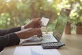 Rear view of modern businessman hands holding credit card typing numbers on computer keyboard while sitting with pen, Royalty Free Stock Photo