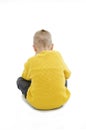 Rear view, of modern little boy, sitting on floor.