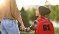 Loving mother and little son schoolboy with backpak holding hands while going to school together Royalty Free Stock Photo