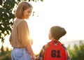 Loving mother and little son schoolboy with backpak holding hands while going to school together Royalty Free Stock Photo