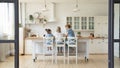 Rear view of mother and two little daughters cooking breakfast Royalty Free Stock Photo