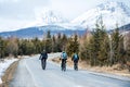 Rear view of mountain bikers riding on road in mountains outdoors in winter. Royalty Free Stock Photo