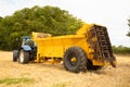 Rear view of a muck spreader attached to a tractor.