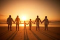 Rear view of multi generation family silhouetted on the beach. Carefree family with two children, two parents and Royalty Free Stock Photo