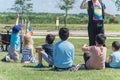 Rear view multicultural children on grass meadow raising hands in outdoor game
