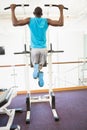 Rear view of muscular man doing pull ups at gym Royalty Free Stock Photo