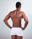 Rear view of one African American fitness model posing topless in a underwear and looking muscular. Black male athlete Royalty Free Stock Photo