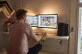 Rear view, one young man, 20-29 years old, sitting, using computer, on the web. looking at images at his home, in his room. Desk w Royalty Free Stock Photo