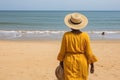 Rear view of an overweight woman walking alone on the beach