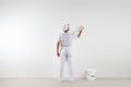 Rear view of painter man looking at blank wall, with paint brush Royalty Free Stock Photo