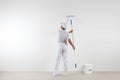 Rear view of painter man looking at blank wall, with paint stick Royalty Free Stock Photo