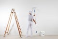 Rear view of painter man looking at blank wall, with paint stick Royalty Free Stock Photo