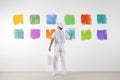 Rear view of painter man who make and chooses from various colors Royalty Free Stock Photo