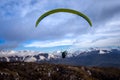 Rear view of paragliding over mountains of Bariloche in Argentina, with snowed peaks in the background. Concept of freedom, Royalty Free Stock Photo