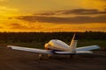 Rear view of a parked small plane on a sunset background. Silhouette of a private airplane landed at dusk.