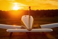 Rear view of a parked small plane on a sunset background. Silhouette of a private airplane landed at dusk.