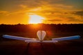 Rear view of a parked small plane on a sunset background. Silhouette of a private airplane landed at dusk.