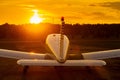 Rear view of a parked small plane on a sunset background. Silhouette of a private airplane landed at dusk.