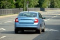 Passenger car moves along an empty city street on a summer day rear view Royalty Free Stock Photo