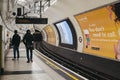 Rear view of people walking on the platform of Embankment tube station, London, UK Royalty Free Stock Photo