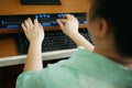 Rear view of person with blindness disability using computer keyboard and braille display or braille terminal a technology