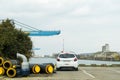 Rear view of Peugeot 208 car parked in front of large industrial port of