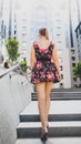 Rear view image of beautiful young woman with long legs wearing short dress walking up the stone stairs on city street Royalty Free Stock Photo