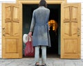 Rear view of a poor man standing in front of open church doors Royalty Free Stock Photo