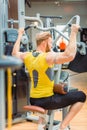 Rear view of a powerful bodybuilder with strong arms exercising at the gym