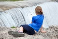 Rear view at preteen age girl sitting on edge of waterfall of the Cijevna river. It is called Montenegrin Niagara Falls. Royalty Free Stock Photo