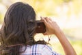 Rear view of pretty brunette in the park using retro camera Royalty Free Stock Photo