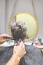 Hairdresser does hairstyle with hair clipper and comb. Barbershop concept Royalty Free Stock Photo