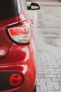 Rear view of red car. Red car on the street. Vehicle part. Rear view of automobile with bacl light. City transportation.