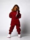 Rear view of red-haired preschooler girl wearing warm tracksuit studio portrait