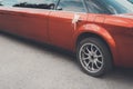 A rear view of a red long limousine with a decoration on the back door handle. The rear part of a festive red limousine Royalty Free Stock Photo